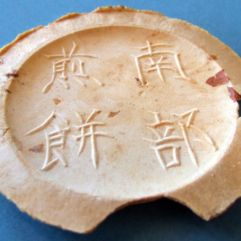 南部せんべい。「南部煎餅」の刻印と、縁の薄い耳がある